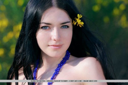 У Olivia F в волосах цветок. А еще она голая