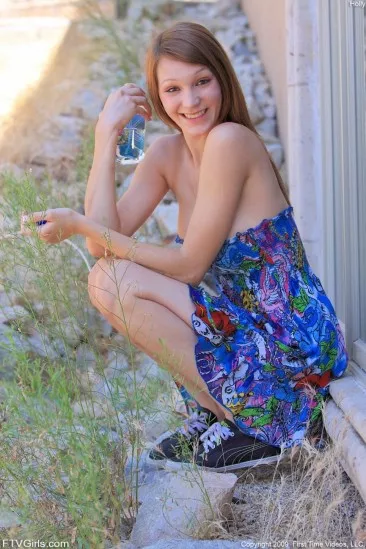 Высокая красотка Holly Michaels в голубом платье раздвигает выбритую киску близко к камере