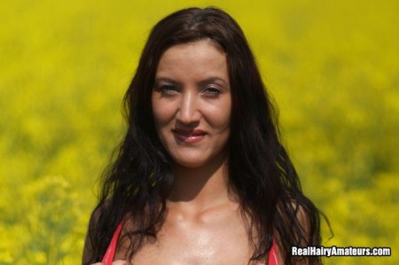 Длинноволосая, грудастая брюнетка Krisztina Ventura в красных трусиках позирует без бюстгальтера в поле